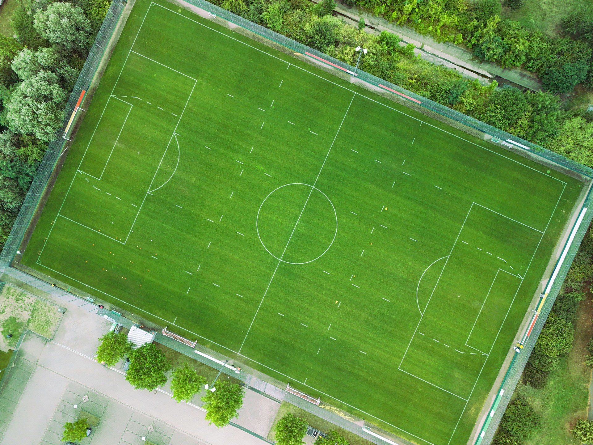 Aerial View of a Green Soccer Field Surrounded by Nature